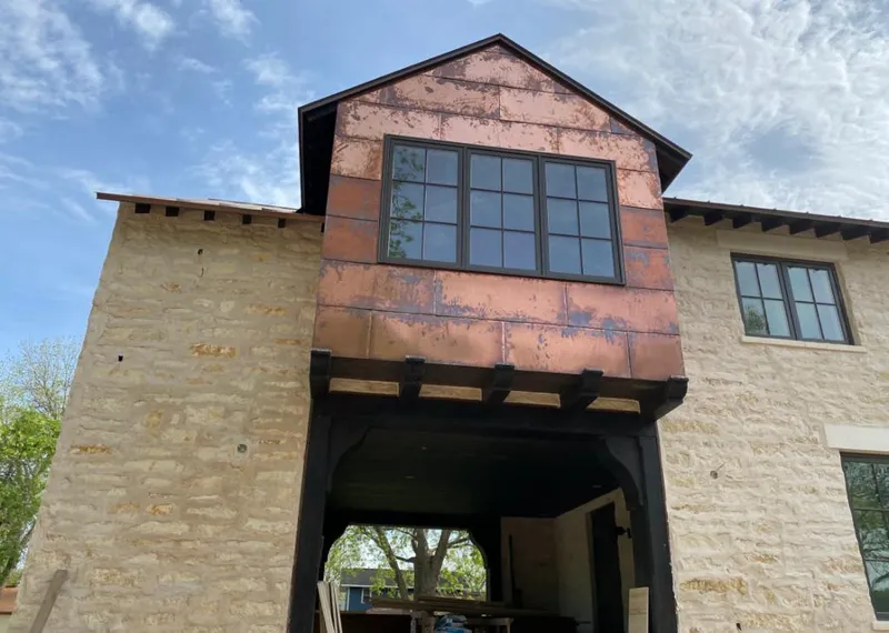 Copper metal panel facade on a stone building for Roof Repair in Aubrey