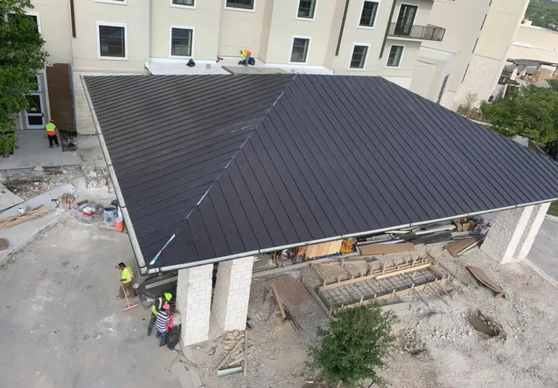Metal roofing installation team working on a commercial building in Aubrey